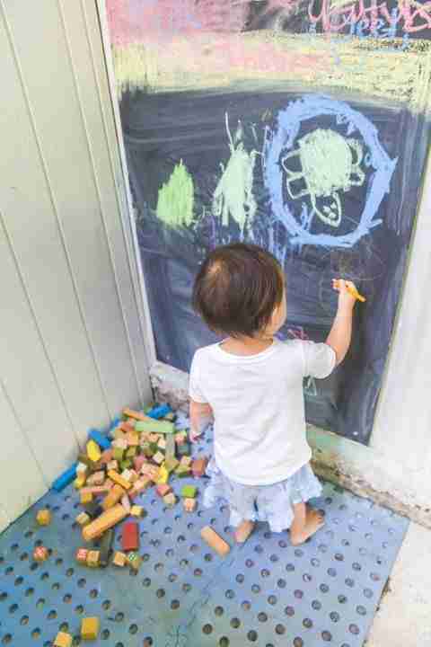 Toddler drawing the turtle she saw on a blackboard in the toddler's corner at coconut crab cafe