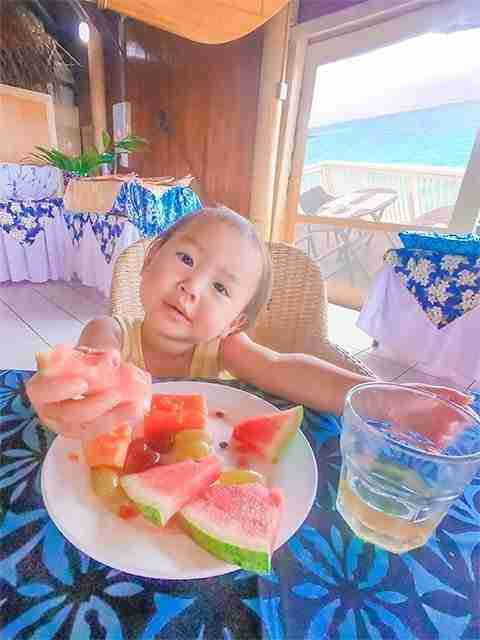 Toddler eating lots of watermelon at The Rarotongan Beach Resort breakfast buffet table