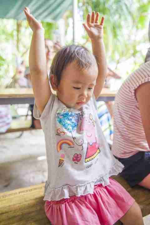 Toddler with arms in the air dancing to the music