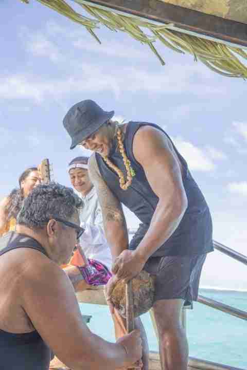 Crew cracking a coconut on the boat